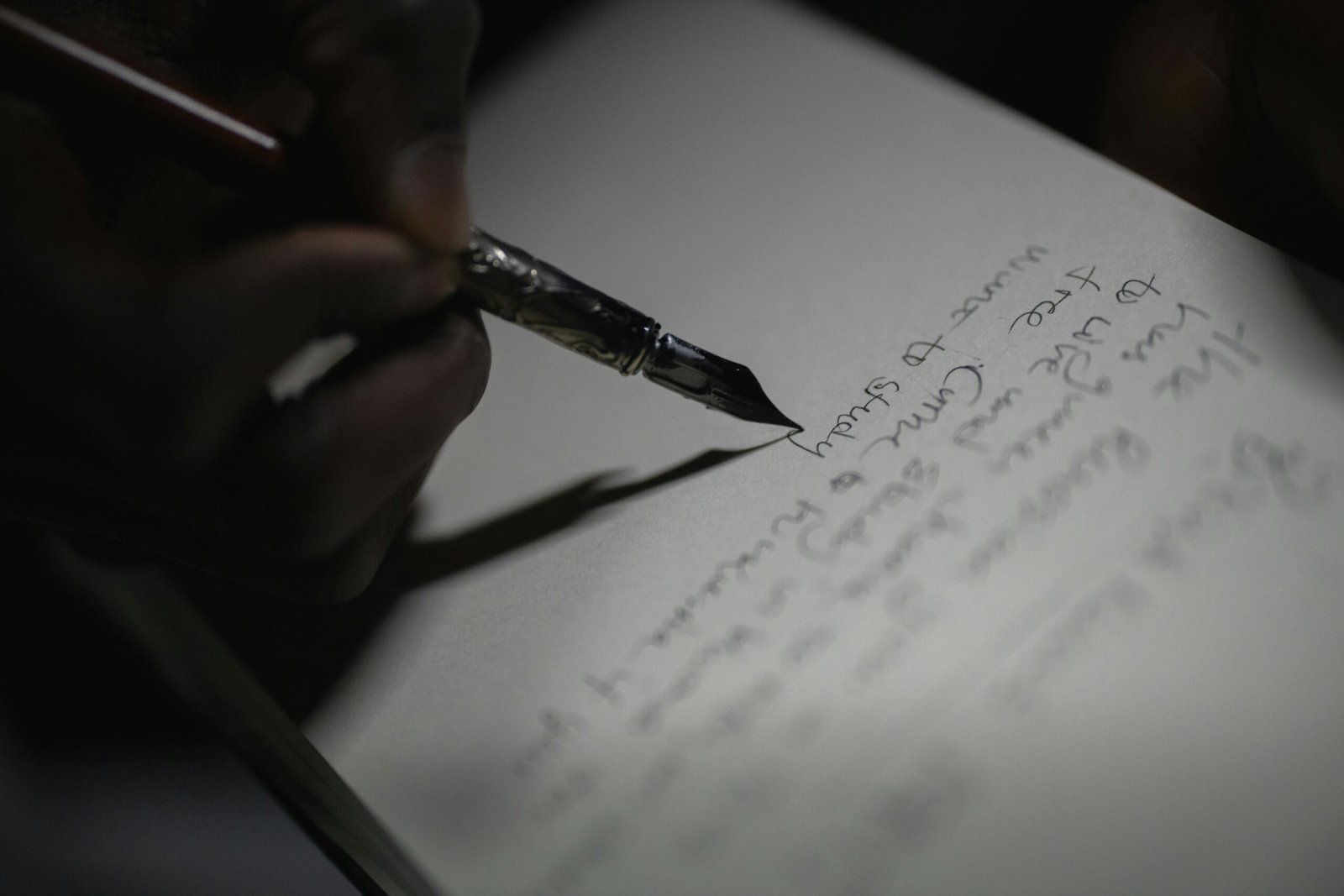 A close-up shot of a hand writing with a fountain pen, capturing the elegance of ink on paper.
